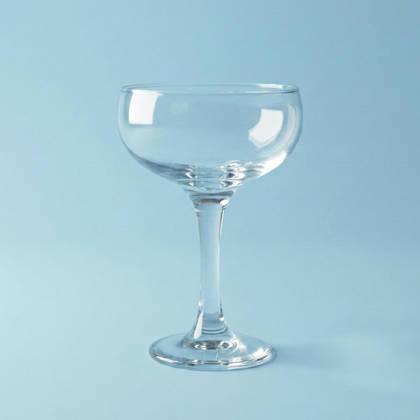 Clear glass cocktail glass on a light blue background