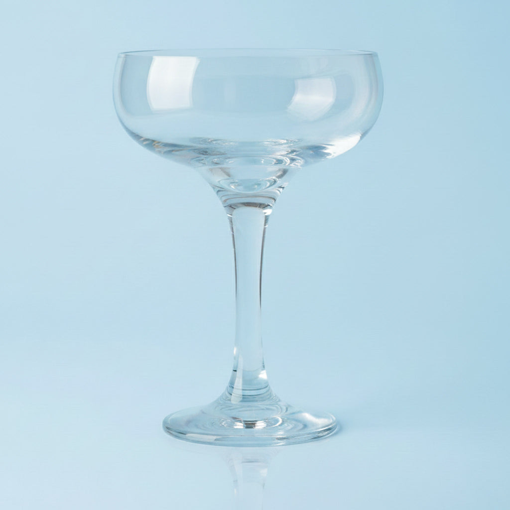 Clear glass coupe on a light blue background