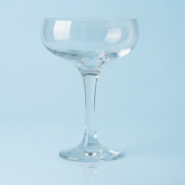 Clear glass coupe on a light blue background