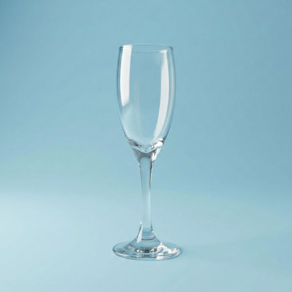 Clear champagne flute glass on a light blue background