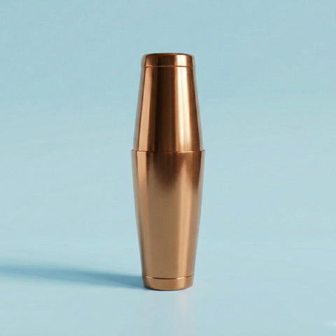 Bronze-colored cocktail shaker on a light blue background
