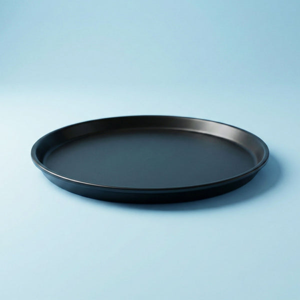 Black round tray on a light blue background