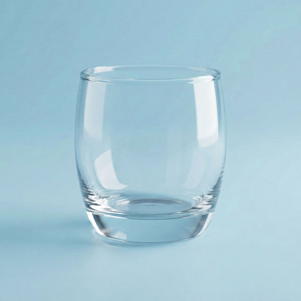 Clear manhatten glass tumbler on a light blue background