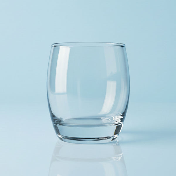 Clear glass tumbler on a light blue background
