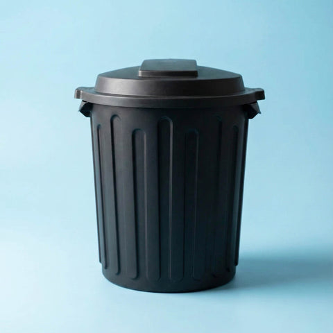 Black trash bin on a light blue background