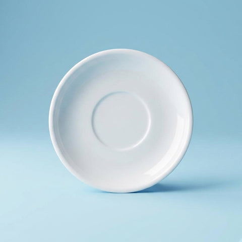 White ceramic tea cup saucer on a light blue background